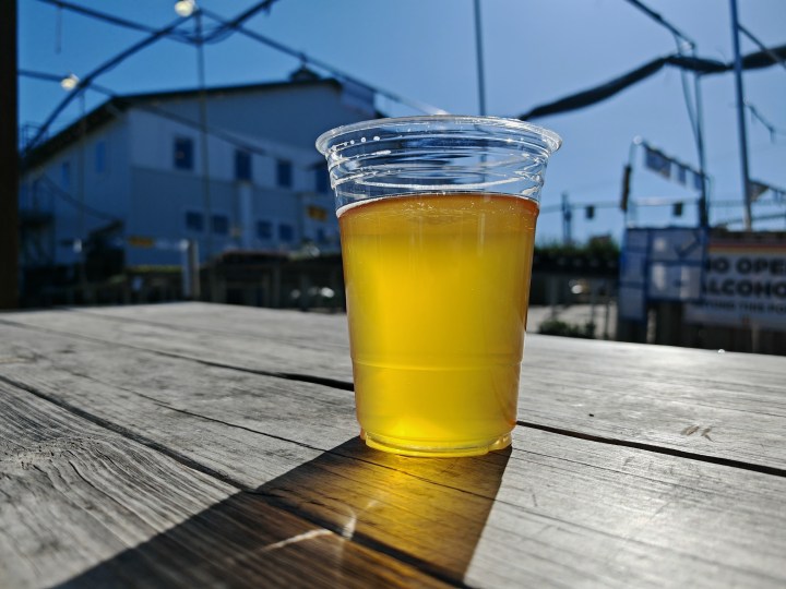 使用荣耀Magic 6 RSR拍摄的塑料杯中啤酒的照片。