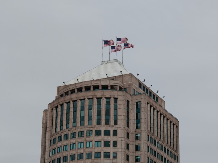 使用荣耀 Magic 6 RSR 拍摄的底特律一座建筑物的照片，其顶部悬挂着四面美国国旗。