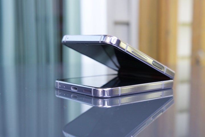 三星 Galaxy Z Flip 5 部分打开，放在桌子上。